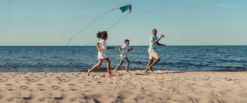 Family Flying Kite on Beach